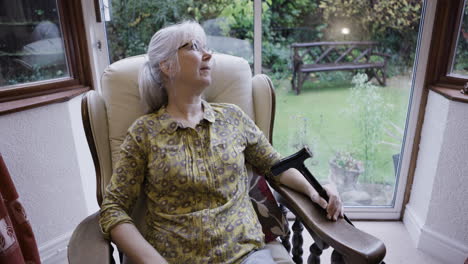 senior woman relaxing in an armchair by the window