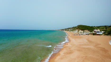 Aerial-drone-shot-over-the-long-stretching-empty-sandy-beach-in-Corfu-in-Greece