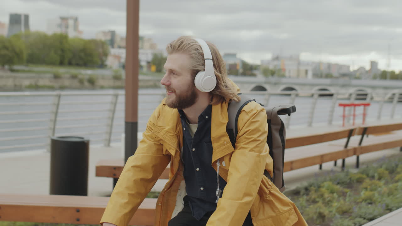 Man in Headphones Riding Bicycle in City