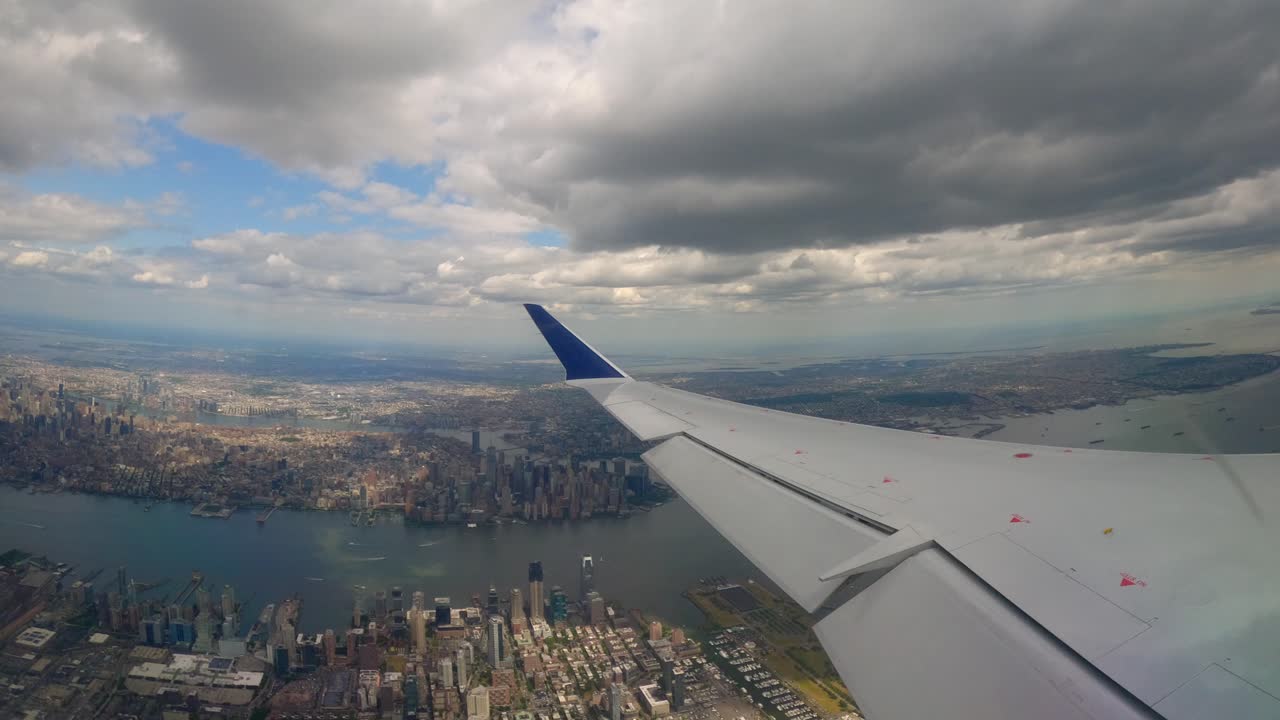 vista de la ventana del avión volando sobre la ciudad de jersey con manhattan, brooklyn y queens en el fondo por la tarde