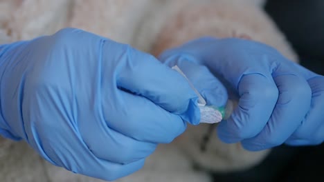 un profesional médico quita la tapa de la aguja antes de recolectar una muestra de sangre