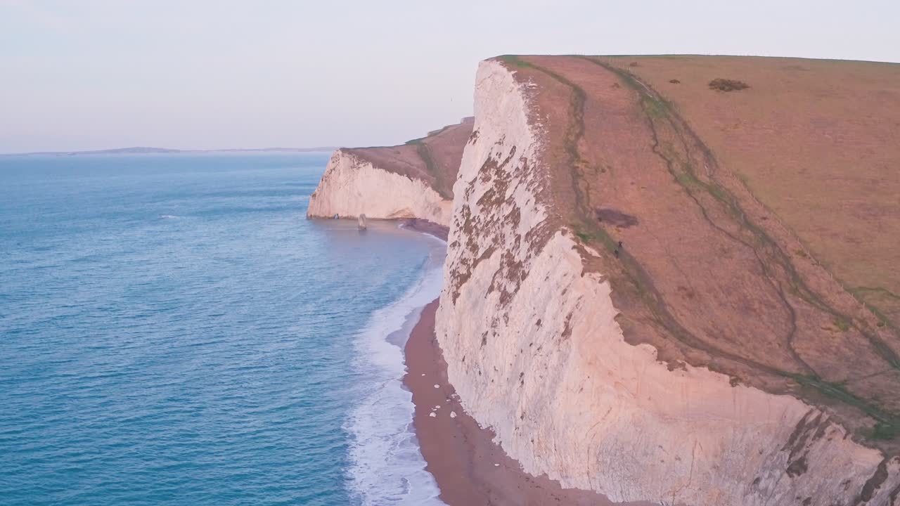 White chalk cliffs at Durdle Door at sunrise, Lulworth Cove, Dorset, England, UK. Aerial drone view