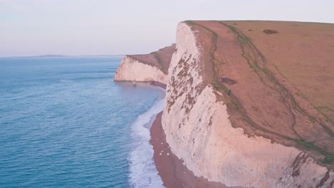 white chalk cliffs at durdle door at sunrise, lulworth cove, dorset, england, uk. aerial drone view