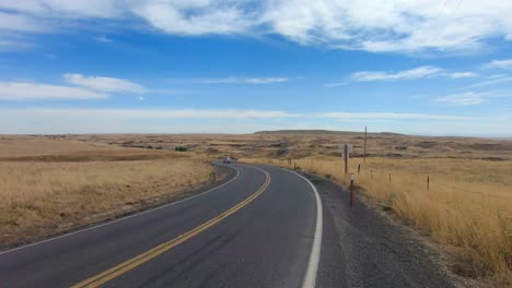 Truck-towing-a-fishing-boat-on-the-highway-and-driving-away-from-the-camera-in-the-Scablands-in-Eastern-Washington-State