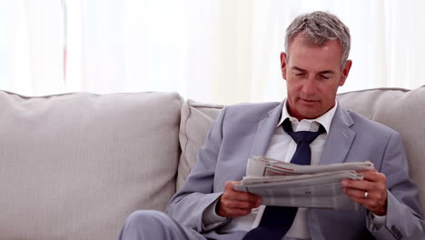 un hombre de negocios sonriente leyendo periódicos.