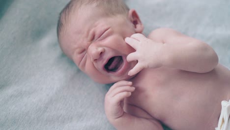 infant-son-with-short-fair-hair-moves-arms-and-lies-relaxed