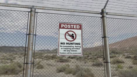 alta calidad 3d cgi render con un plano suave de dollying-out de una valla de enchaines en una instalación de alta seguridad en una escena del desierto, con un signo de no caza no intrusión