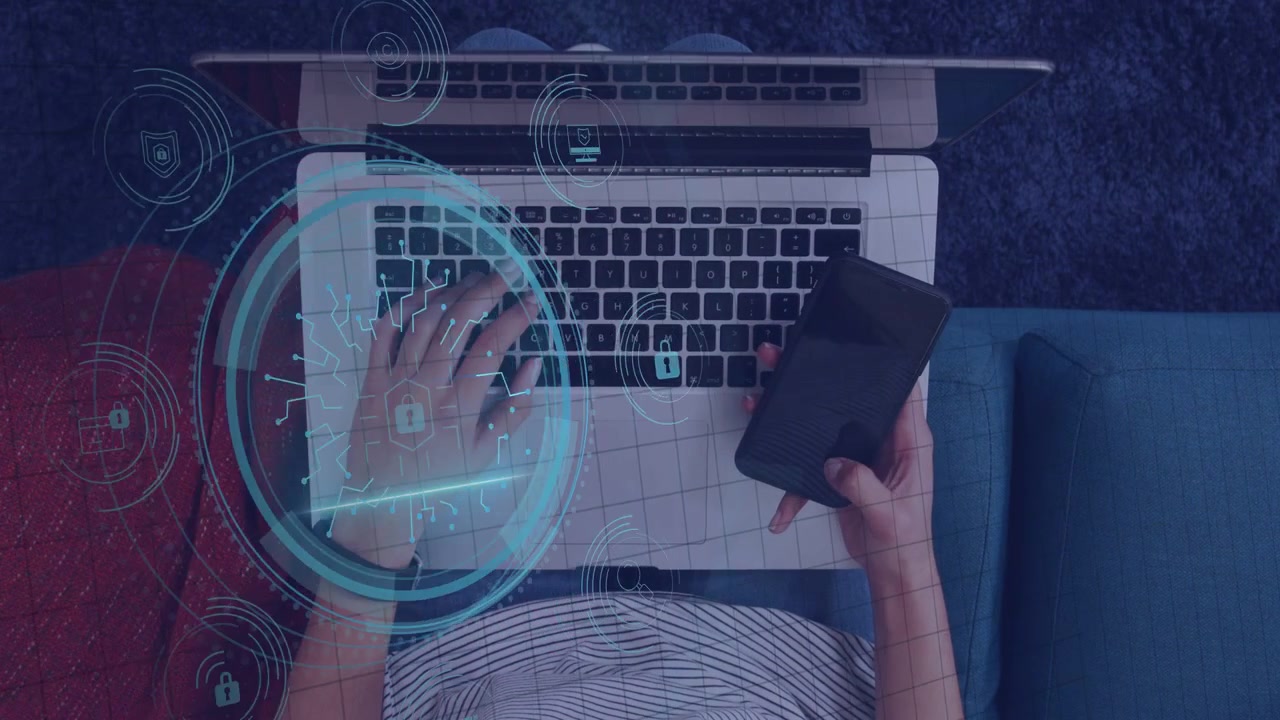 Kvinde taster og trykker på telefon på sofa, starter cybersikkerheds-HUD, der udvides omkring tastaturet.
