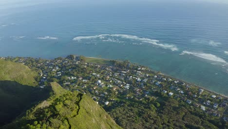 aerial shot of a hiking trail on the top of a steep tropical mountain near the pacific ocean in kaaawa hawaii