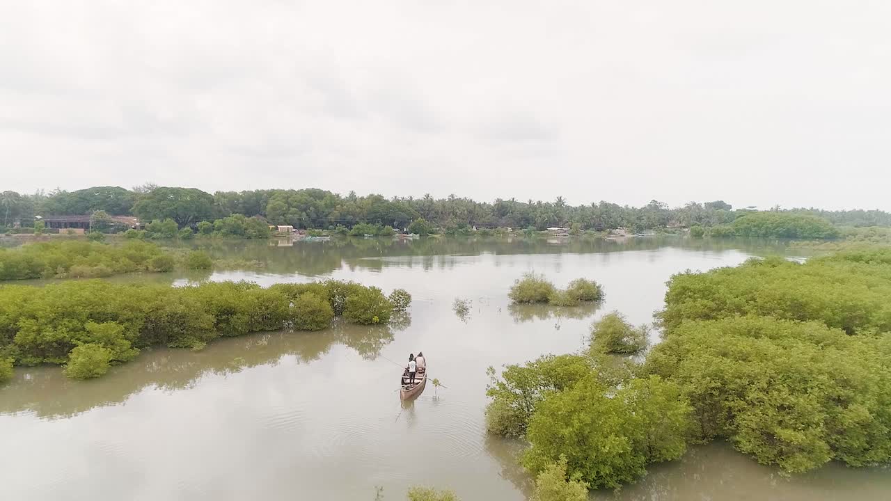 Luftfoto af parret, der nyder en lang bådtur i vandkanalerne i de vestlige Ghats i Sydindien.