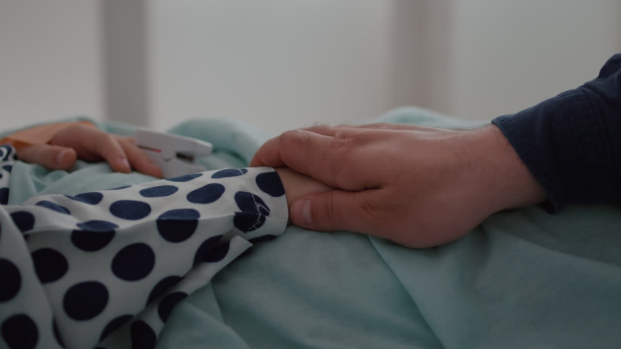 Closeup of sick child resting in bed with oximeter on finger monitoring disease expertise