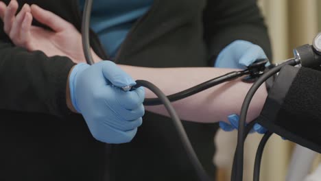 nurse taking blood pressure of a patient with video close up.