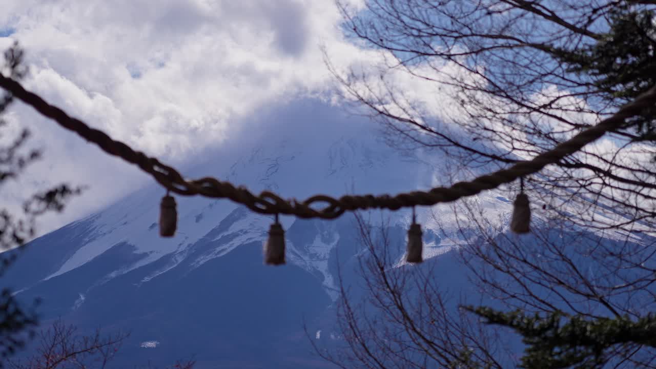 Mount Fuji seen through traditional shimenawa rope from temple grounds. Traditional Shinto rope