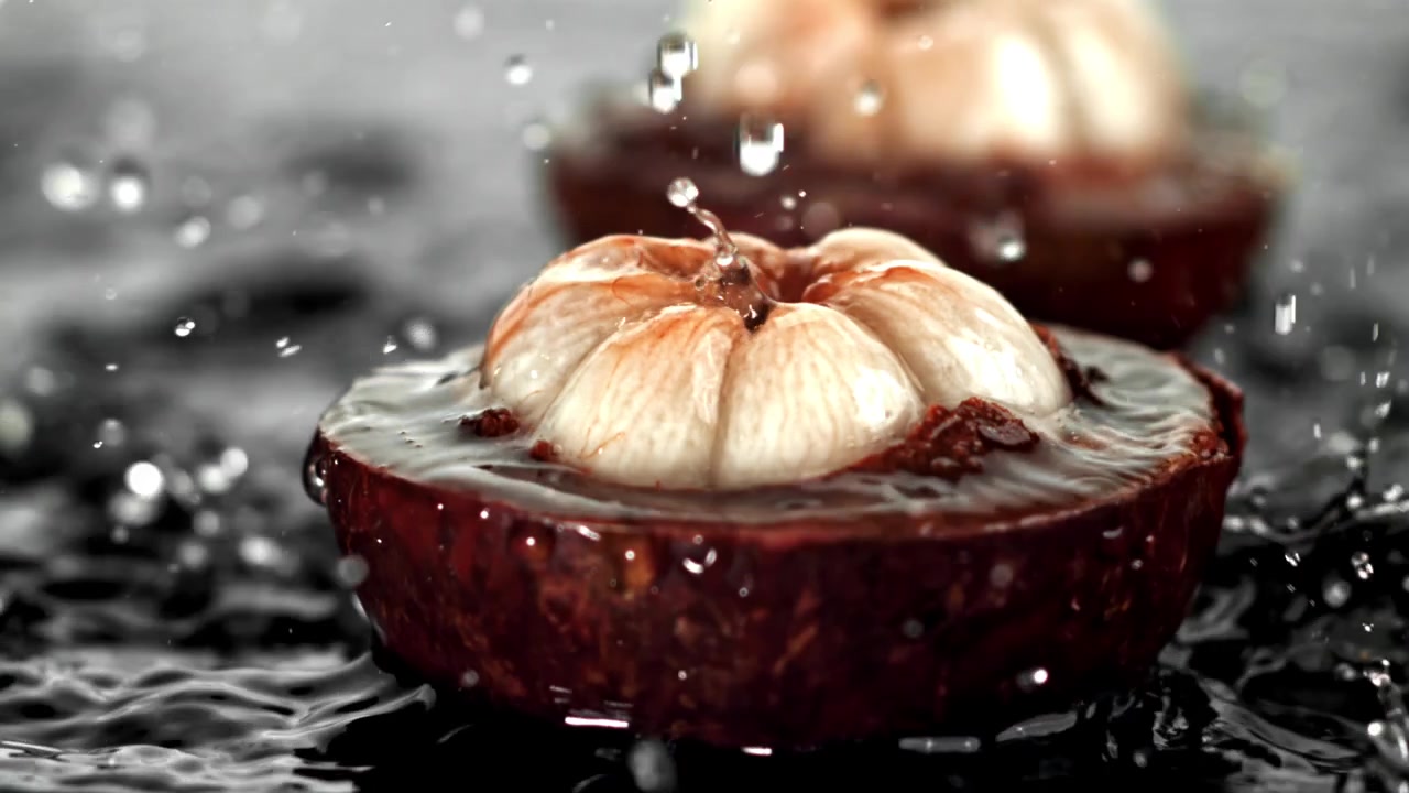 Forfriskende mangostanfrugt med vandstænk i slowmotion