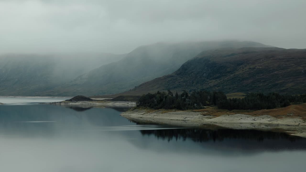Descending approach over Loch Cluanie, Scotland, with scenic highland views and mist-covered hills, tranquil lake scenery
