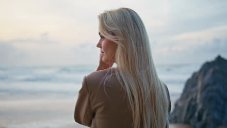 fashion model posing sunset beach at cloudy sky. closeup sexy blonde in suit