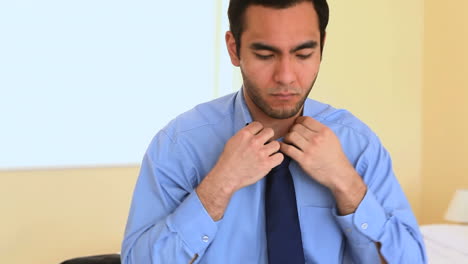 businessman tying his tie