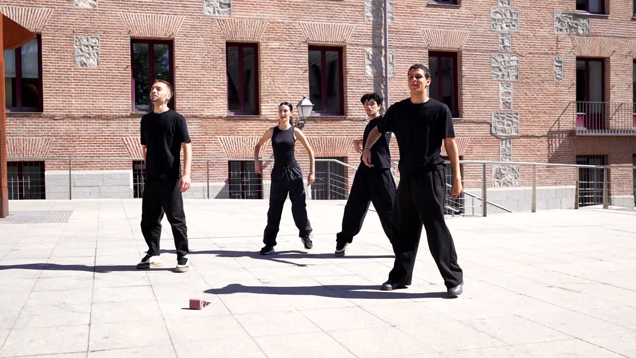 Un gruppo di giovani adulti che si esibiscono in una street dance in una piazza cittadina