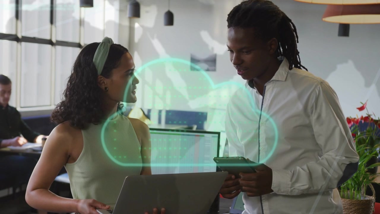 Pair reviewing laptop, woman pointing causing teal cloud overlay third seated for tech review