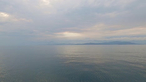 wide angle pov of cruising above calm and peaceful sea in the evening