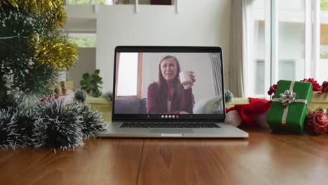 Mujer-Caucásica-Sonriente-Tomando-Café-En-Una-Videollamada-Navideña-En-Una-Computadora-Portátil