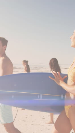 animation of light over happy diverse friends walking on beach with surfboards