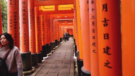 persona caminando bajo las tradicionales puertas torii japonesas