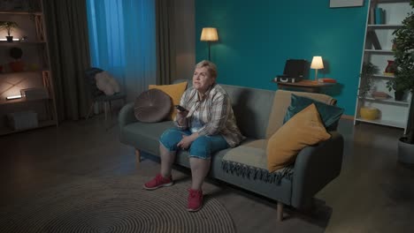 mujer anciana viendo la televisión en casa