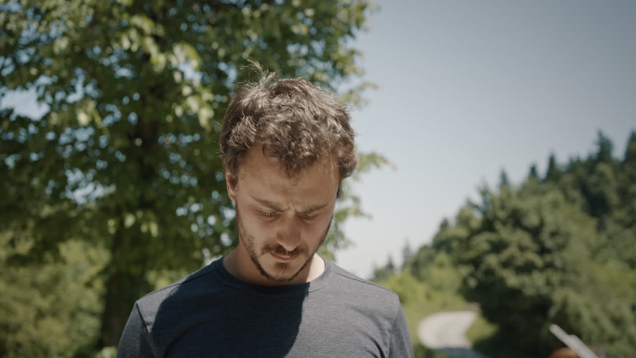 молодой человек останавливается, рассматривает свой буклет и окружающую обстановку