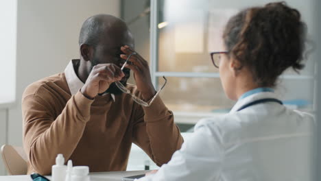 Afrikanischer-Mann-Spricht-Mit-Einer-Ärztin-über-Eine-Konsultation-In-Der-Klinik