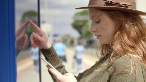 mujer joven comprobando el horario en la ciudad