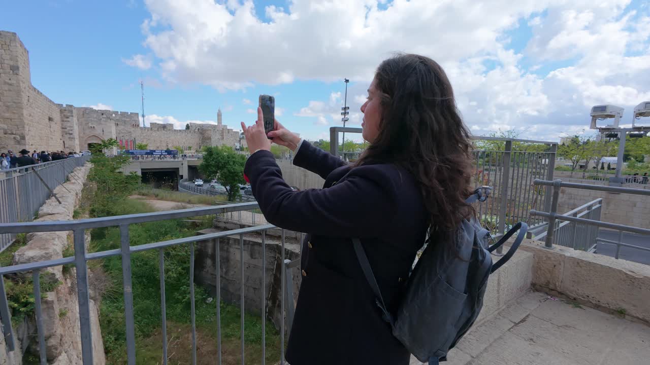 Young Woman Using Smartphone Near Old City Walls in Jerusalem. Slow motion.