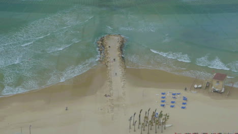 Vogelperspektive-Auf-Den-Strand-Und-Das-Meer-Mit-Felsigem-Pier