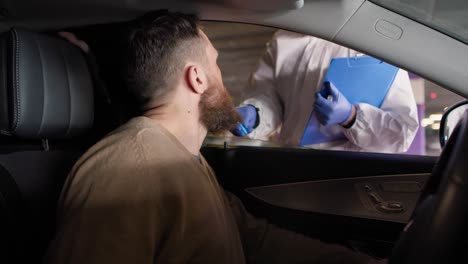 video de mano de un trabajador médico realizando una prueba de covid-19 en un drive-thru