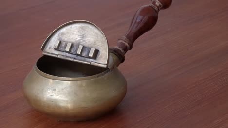 brass ashtray with antique look on wood table, displaying elegance