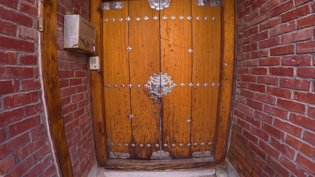 Seul, Güney Kore'deki Bukchon Hanok Köyü'nde metal tokmaklı geleneksel ahşap kapı. - Aşağı eğimli çekim.