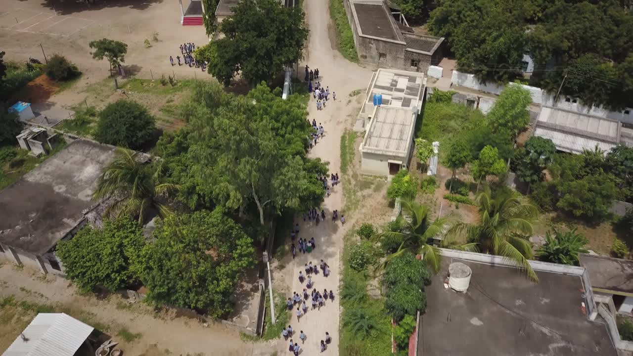 toma aérea de niños caminando a casa en las calles después de la escuela en india, asia