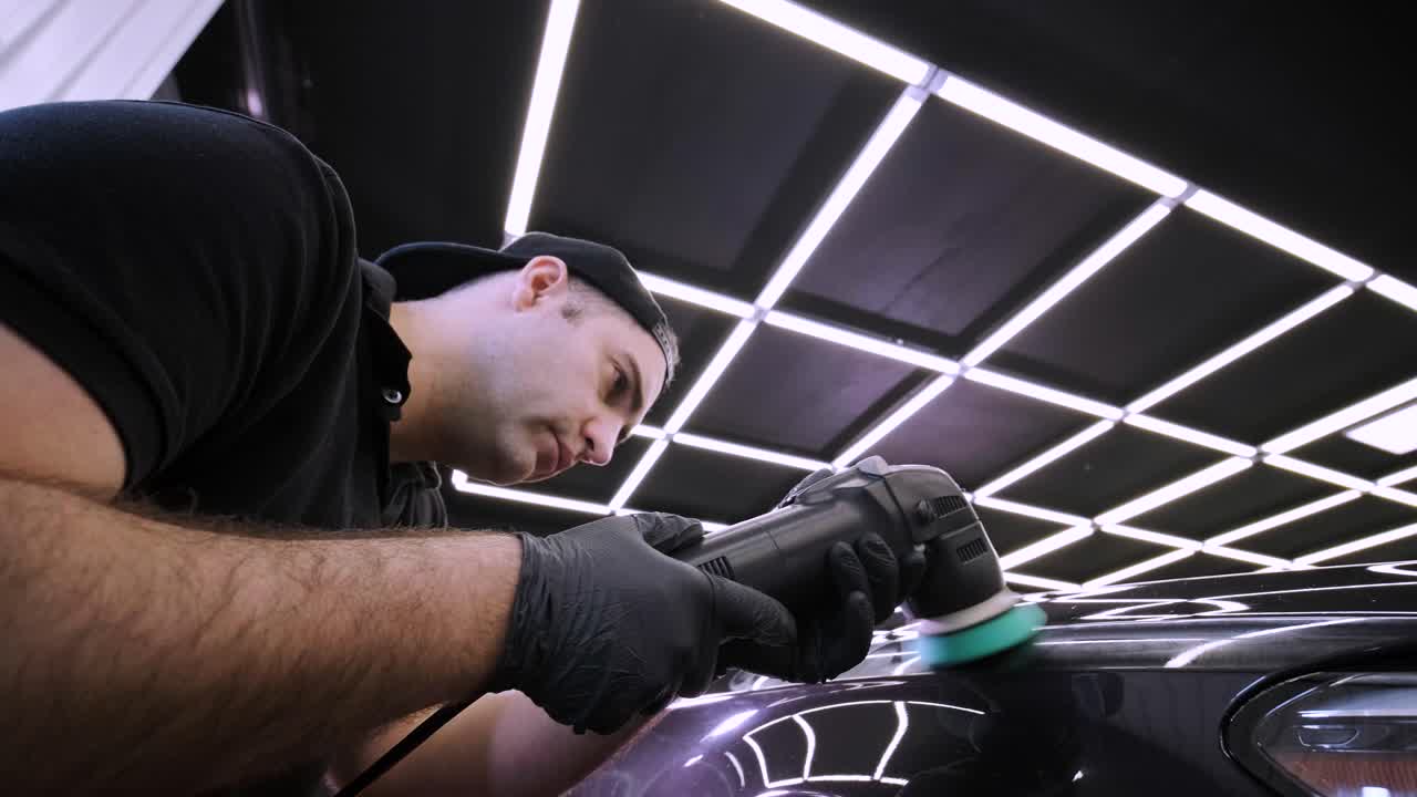 페인트 복원을 위해 기계와 폴리셔를 사용하는 전문 자동차 디테일링.