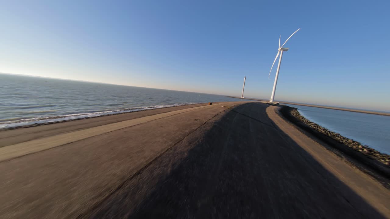 Fast shot towards a windturbine at the end of a dyke on the island Neeltje Jans