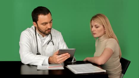 médico con tableta discutiendo paciente en la clínica en una pantalla verde, clave de croma