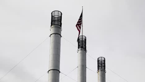 US-Flag-Atop-Of-Bend's-Old-Mill-Smokestack-In-Bend,-Oregon