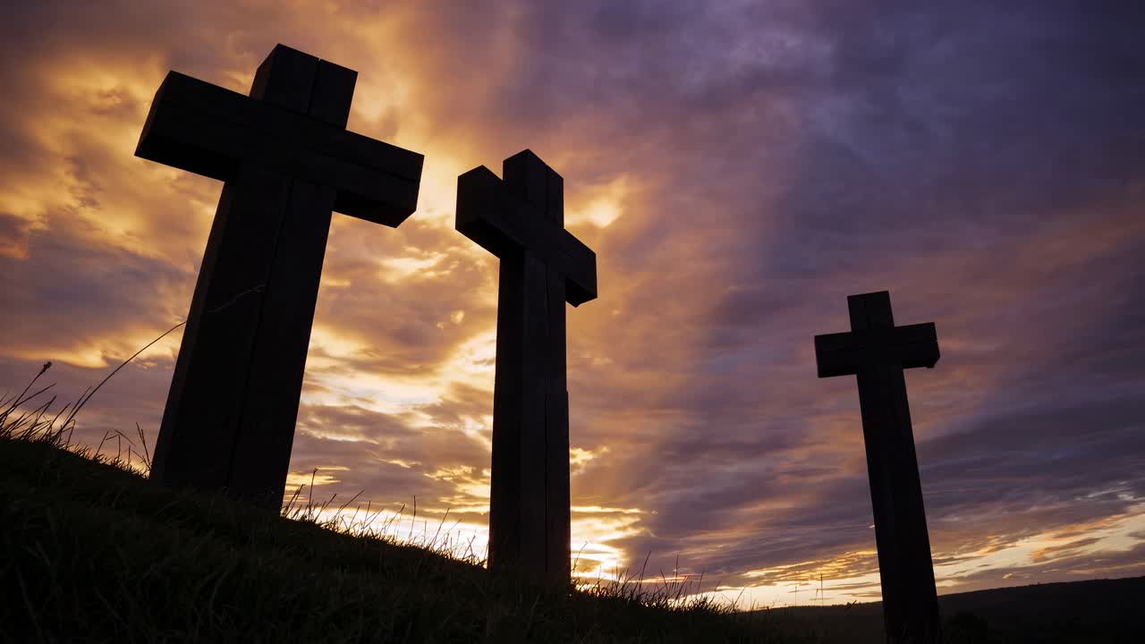 Croci in silhouette con un cielo drammatico al tramonto, riprese da un angolo basso