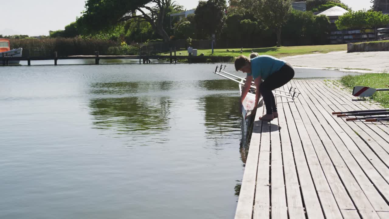 두 명의 고위 백인 여성이 배를 강으로 내리고 있습니다.