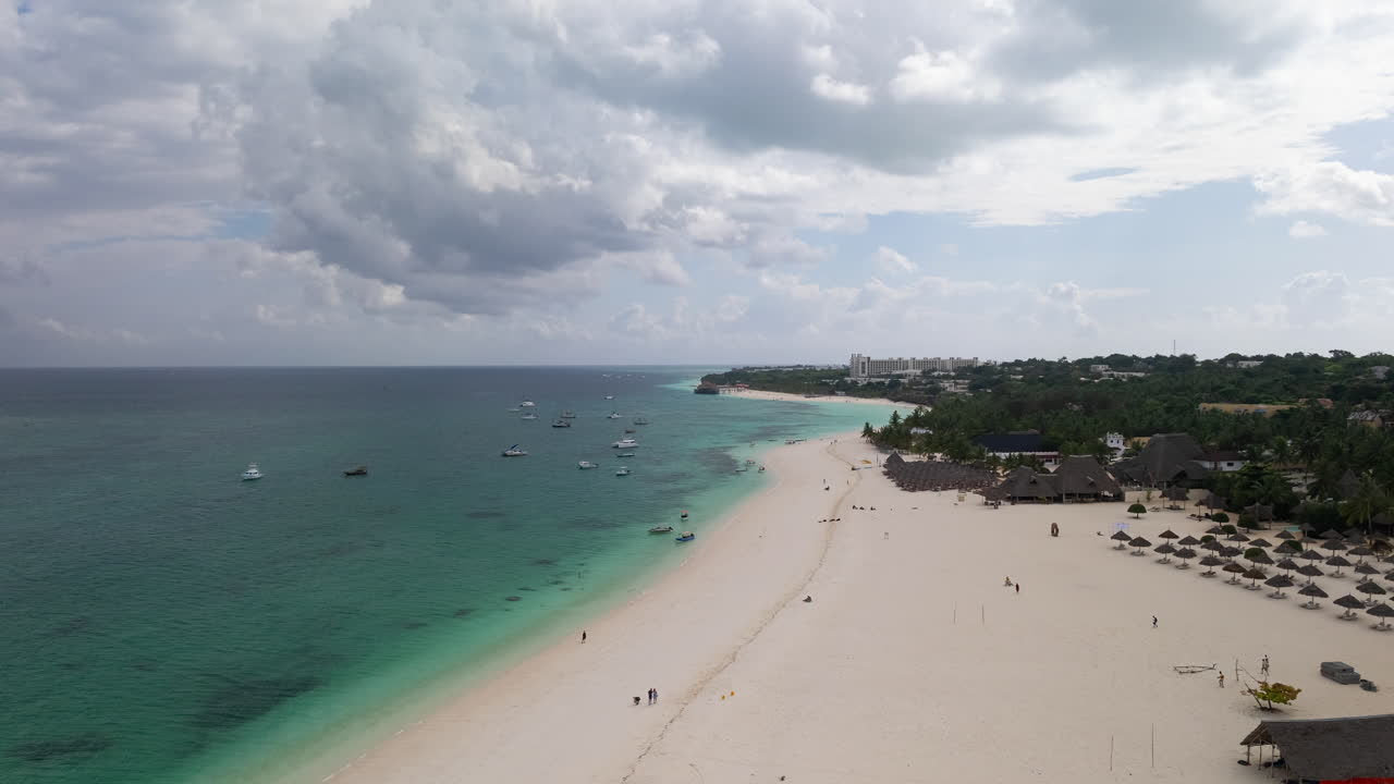 Zanzibar'ın kumlu plajının ve berrak yeşil suyunun 30 fps'de hareketli zaman atlamalı kuşbakışı görünümü