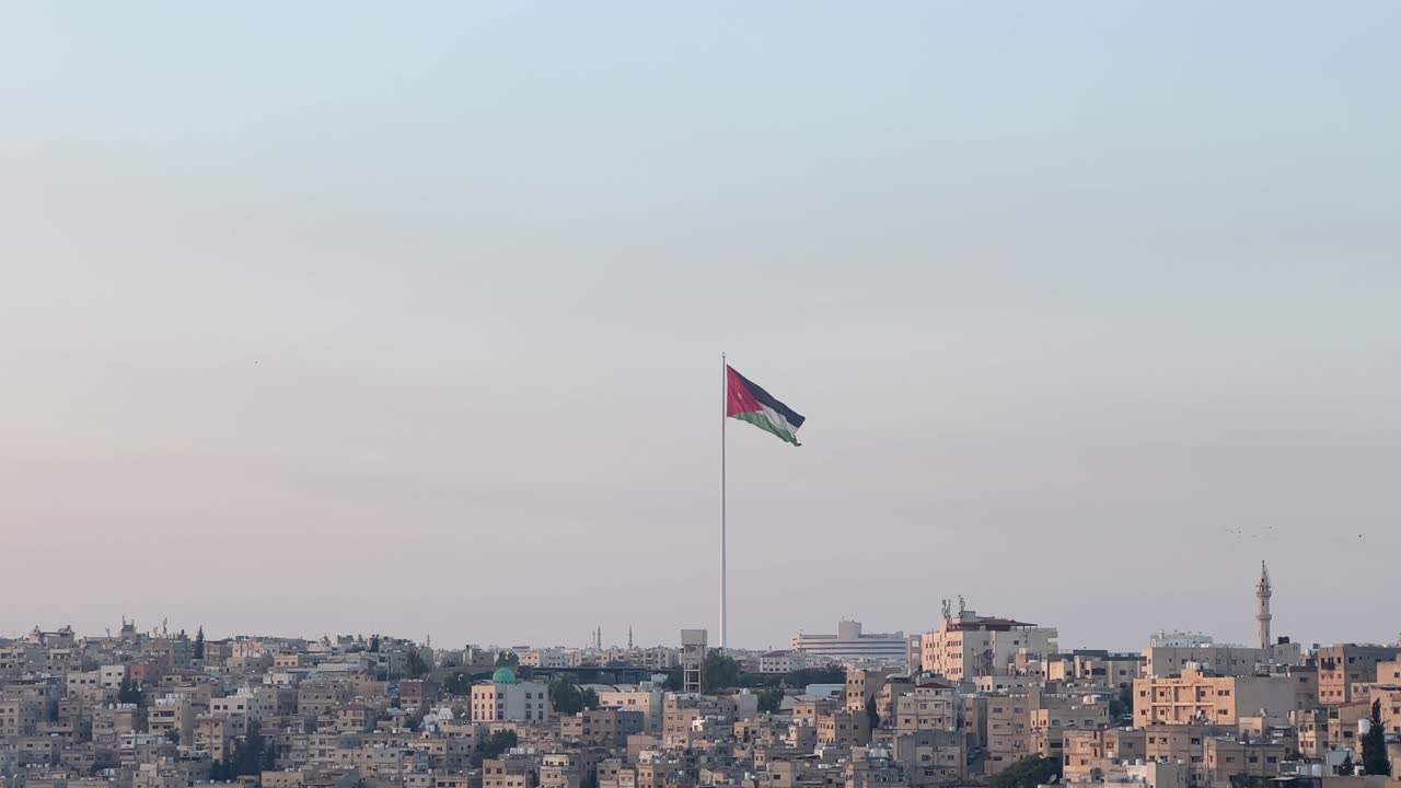 vista desde la ciudadela de ammán en jordania con vistas al centro de ammán y la bandera jordana