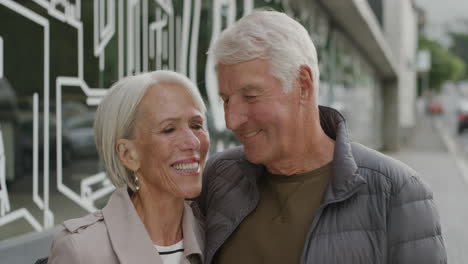 portrait of happy middle aged couple hugging smiling embracing enjoying togetherness looking at camera in urban city street successful relationship