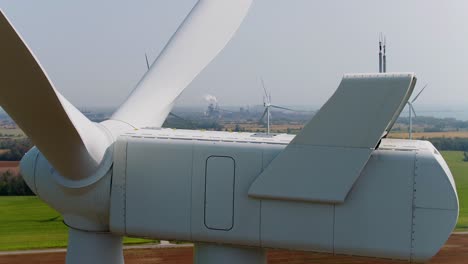 wind turbine nacelle with propeller blades close up aerial drone shot panning