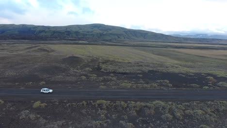 Aerial-drone-shot-of-a-car-driving-offroad-in-Iceland.-Sideway