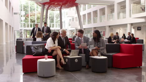 businesspeople meeting in lobby of modern office shot on r3d