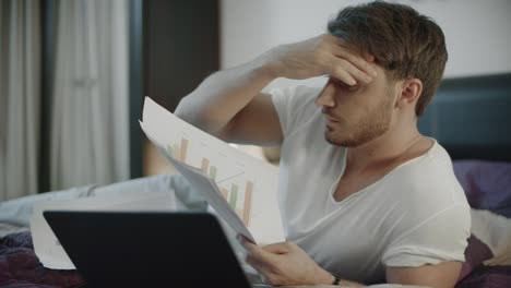 concentrated business man working with papers at home workplace at evening